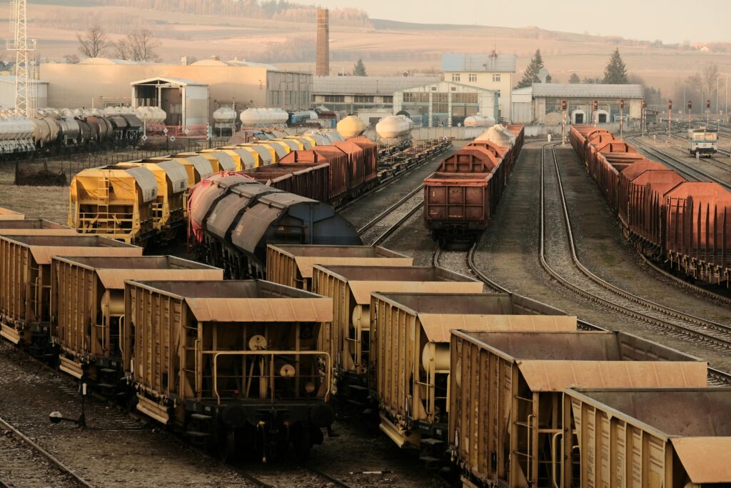 pexels-photo-30858911-30858911 A busy freight train yard with multiple tracks and a variety of train cars in a rural setting.